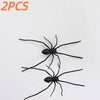 A pair of realistic black spiders used as fridge magnets or horror decor