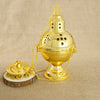 A gold-plated Orthodox censer with bells mounted on a stand, suspended by a chain.