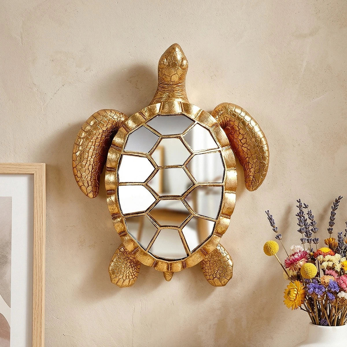 Golden sea turtle resin wall decor mirror with textured gold frame hanging on a beige wall.