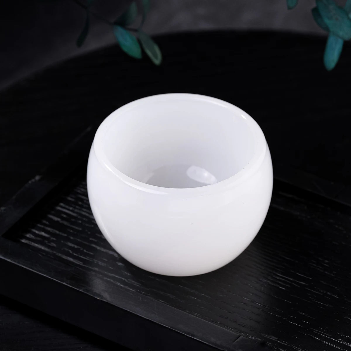 A white crystal agate healing bowl resting on a dark wooden surface.