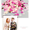 Pink and gold multicolor paper confetti scattered on a gray background with a photo of a couple.