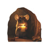 A small brown mouse with large ears holds a lit candle in a dark, draped background.