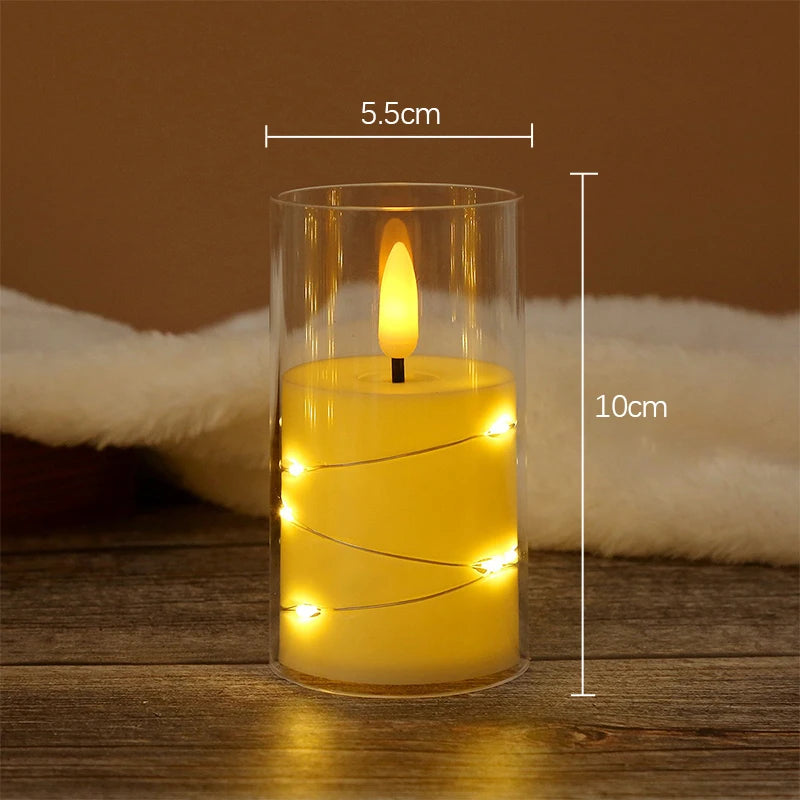 A tall glass candle holder containing a glowing yellow LED star string candle with a visible flame, set on a wooden surface.