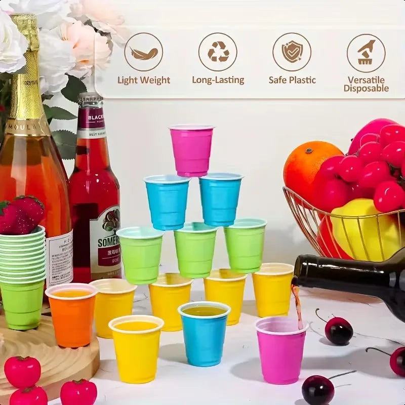 A variety of colorful disposable plastic shot cups in pink, green, yellow, and blue are displayed on a white surface.