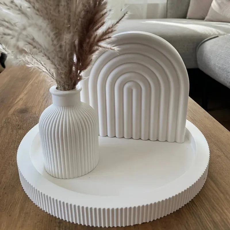 White ribbed silicone mold for crafting vases and trays resting on a wooden surface.