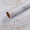 Roll of matte marble self-adhesive waterproof wallpaper lying on a white marble surface