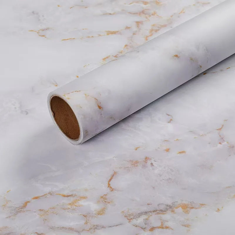 Roll of matte marble self-adhesive waterproof wallpaper lying on a white marble surface