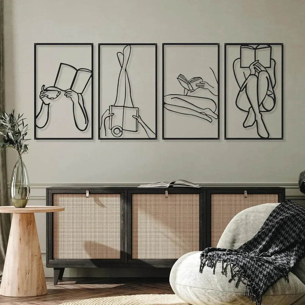A set of four black line art prints depicting female figures in various poses displayed on a wall above a wooden cabinet.