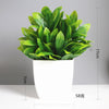 A vibrant green artificial bonsai plant with eucalyptus leaves in a white pot.