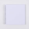 A blank white spiral-bound notebook or scrapbook for DIY memory keeping.