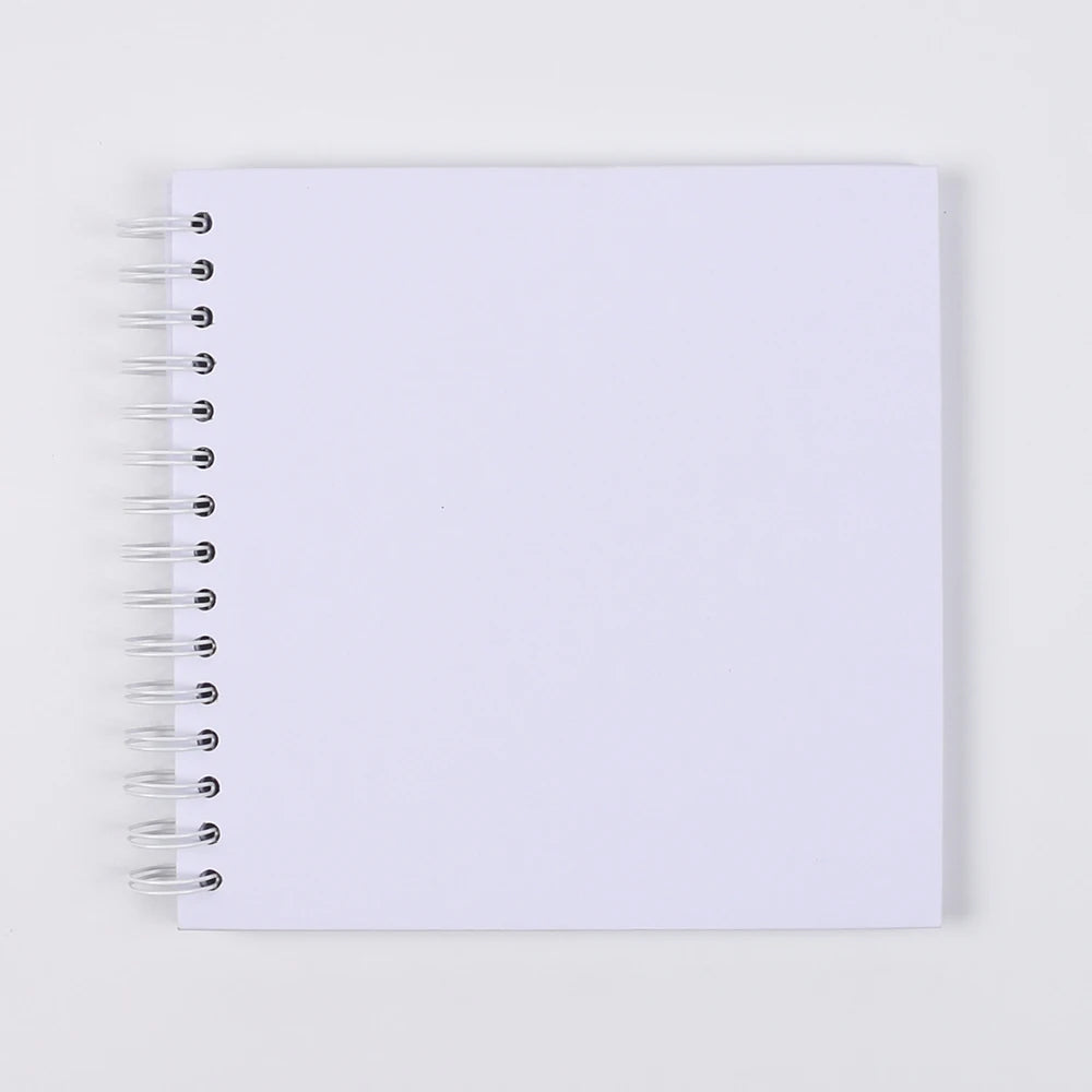 A blank white spiral-bound notebook or scrapbook for DIY memory keeping.
