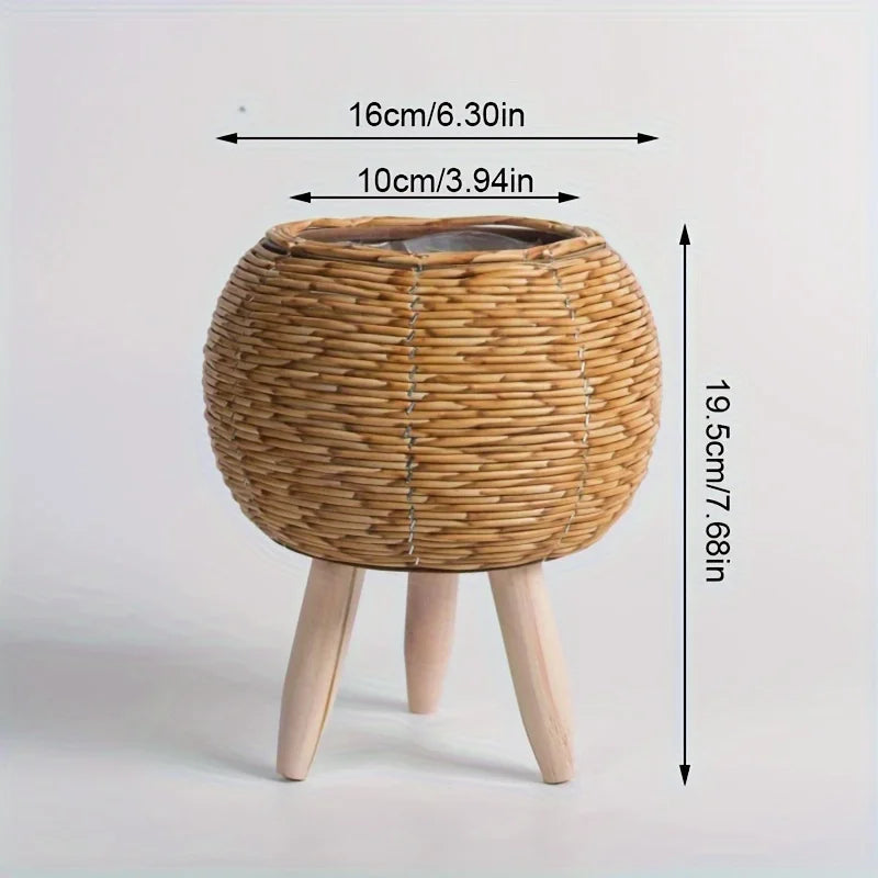 A round rustic rattan planter with a lid and wooden legs, measuring 16cm in diameter and 19.5cm high.