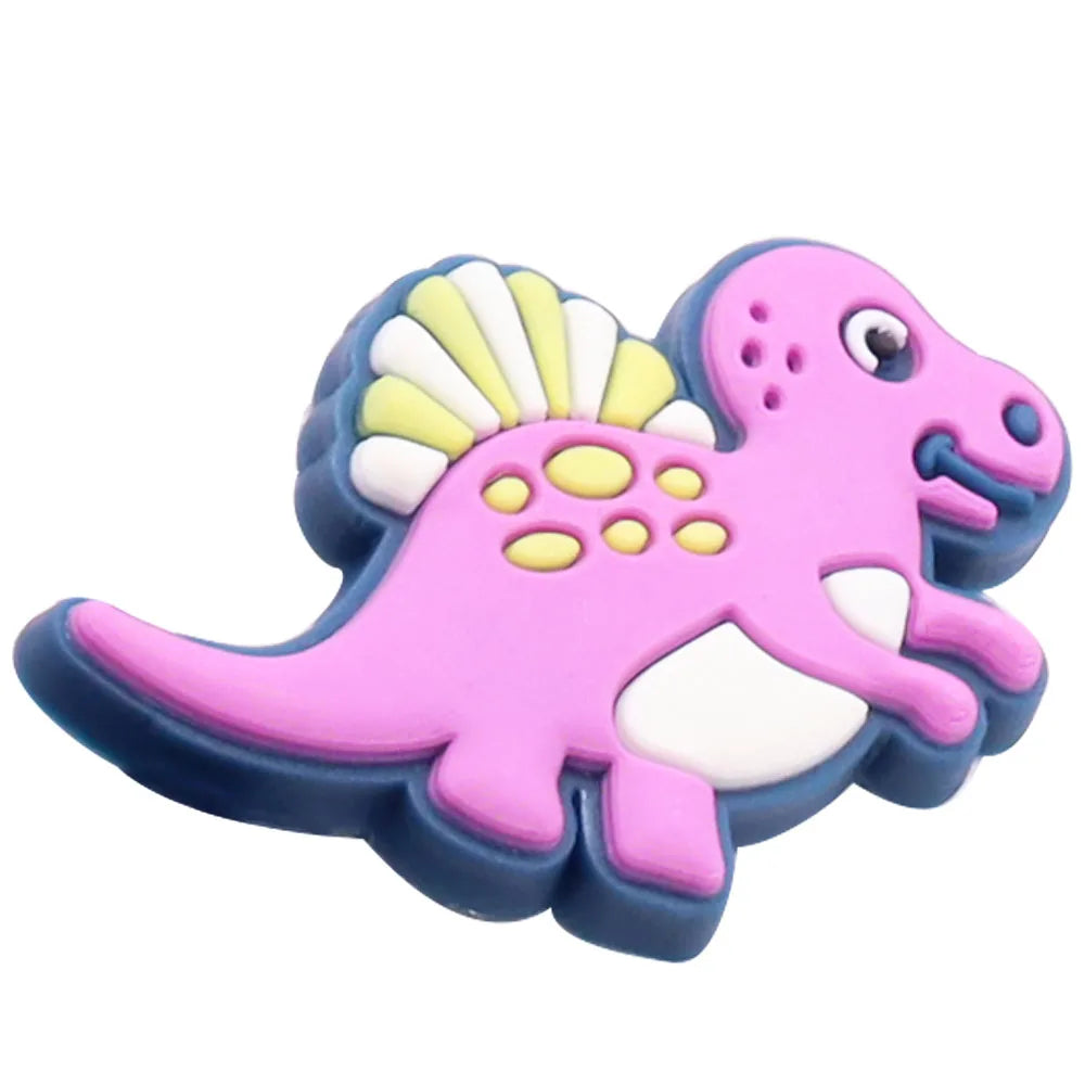 A set of twelve pink and blue cartoon dinosaur PVC shoe charms featuring yellow crests.