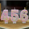 A set of pink macaron number birthday candles displaying the numbers 4, 5, and 6.