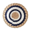 Round woven straw wall decor hanging with concentric rings of white and dark blue