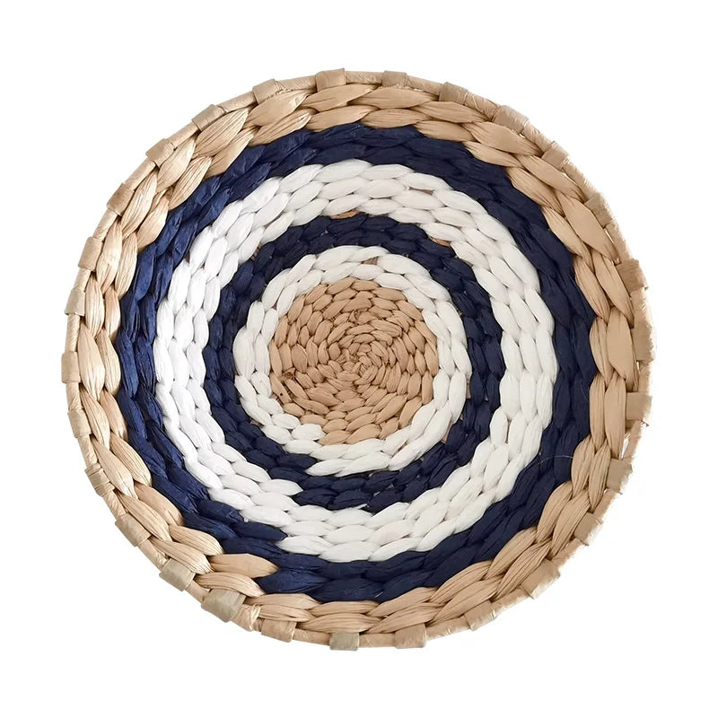 Round woven straw wall decor hanging with concentric rings of white and dark blue