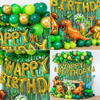 A vibrant birthday party decoration featuring a green tinsel curtain and gold foil balloons shaped like dinosaurs.