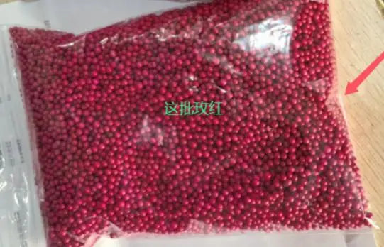 كيس بلاستيكي شفاف مملوء بحبيبات رغوية وردية داكنة لصنع الحرف اليدوية.