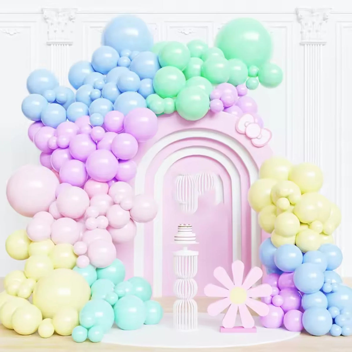 A colorful arrangement of pastel pink and blue latex balloons forming a decorative arch and clusters.