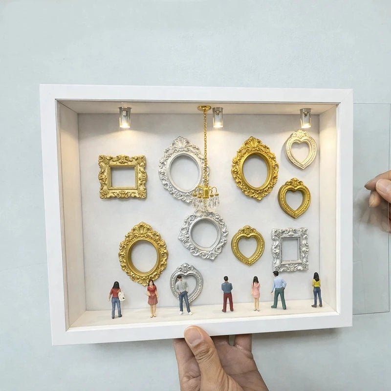 Weiße Schaufensterbox mit verschiedenen Gold- und Silber-Harzsilhouettenrahmen zur Erinnerungsdarstellung.