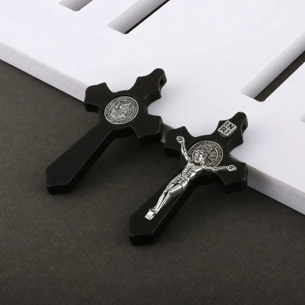A set of black wooden crucifix pendants featuring the image of Jesus Christ.