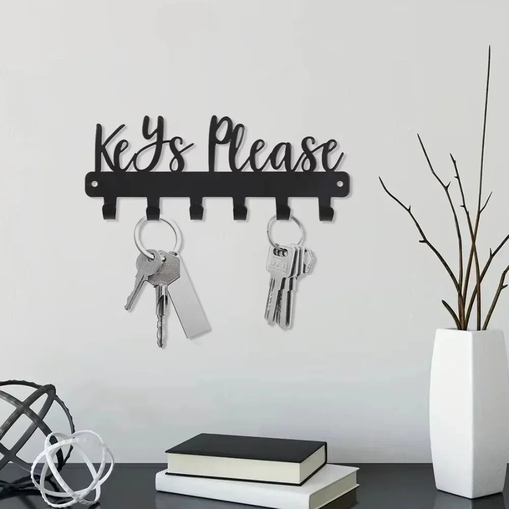 Black wall-mounted metal key holder with hooks displaying the text Yes Please