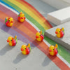 A set of mini resin colorful duck decorations scattered on a rainbow-colored surface.