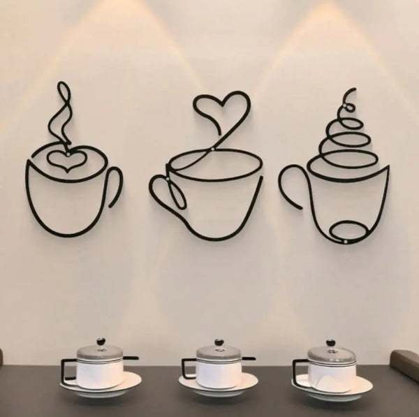 A trio of black metal wall art depicting steaming teacups against a white wall.