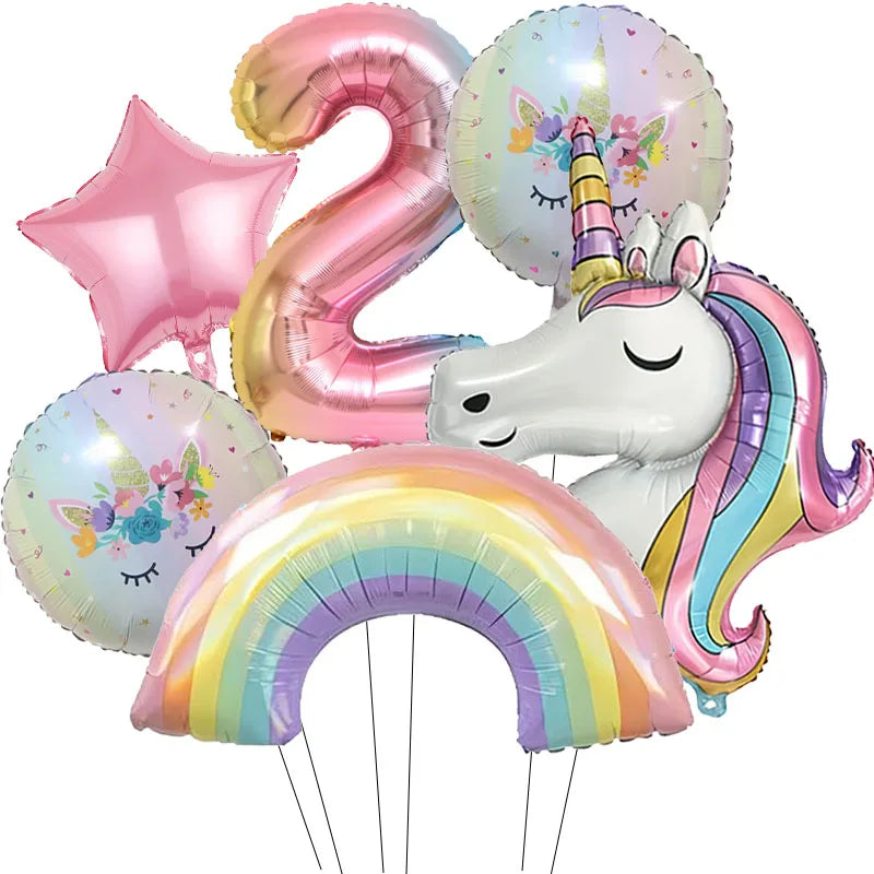 A bunch of iridescent foil balloons shaped like the number 2 and a unicorn, featuring rainbow colors.