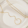 Gold ultra-thin layering chain necklaces with small diamond accents displayed on a white plate.