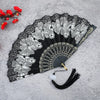 A black and white antique folding fan decorated with detailed bamboo flower patterns.