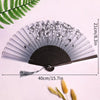 Elegant black and silver bamboo folding hand fan with a tassel displayed on a white background.