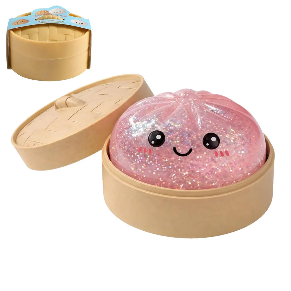 A pink glittery squishy toy shaped like a cute dumpling is shown with its packaging and a separate tray.