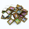 A pile of miniature framed wall art featuring colorful illustrations for dollhouse decor