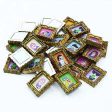 A pile of miniature framed wall art featuring colorful illustrations for dollhouse decor