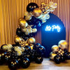 A vertical arrangement of black and gold latex balloons creating a decorative backdrop.