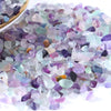 A pile of tumbled gemstone chips in various shades of purple, blue, and green.