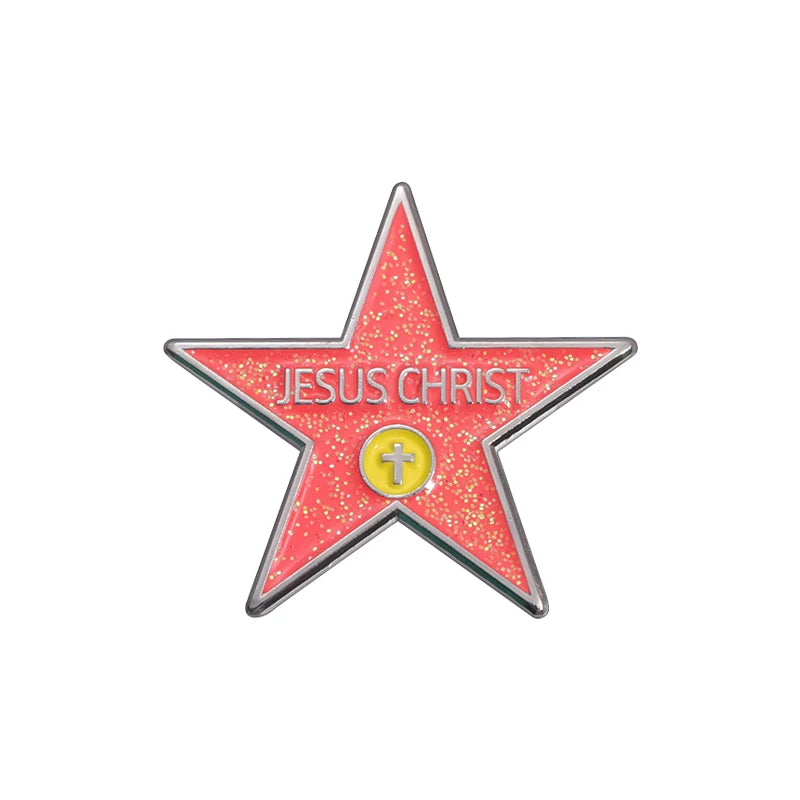 A red star enamel pin with the words JESUS CHRIST and a cross in the center.