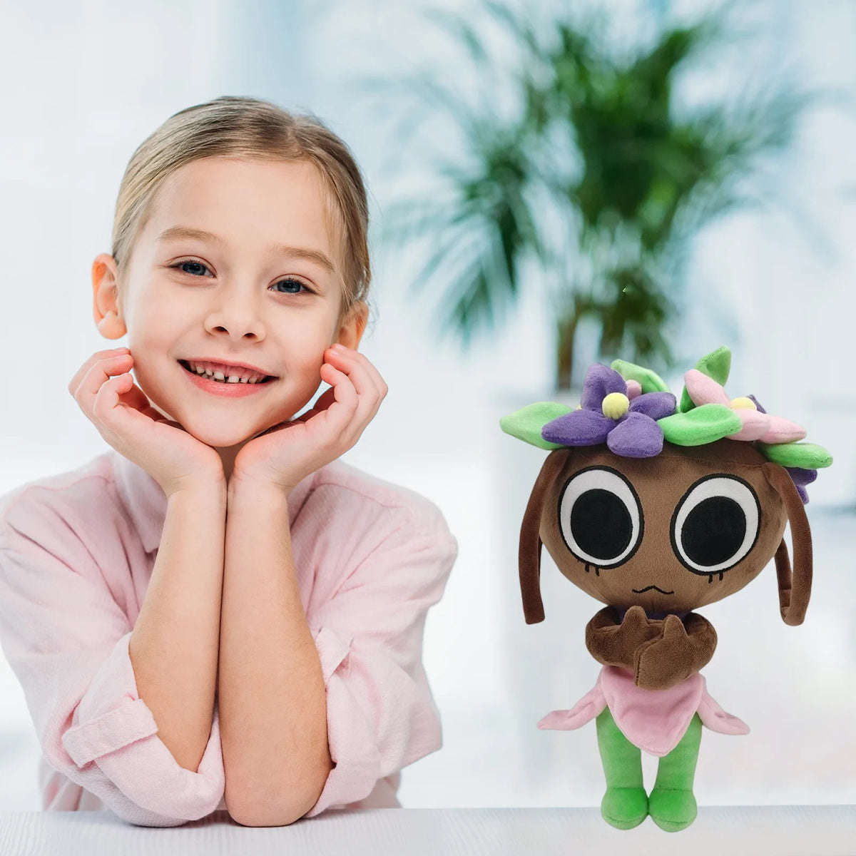 A young girl is holding a brown Goob Boxten plush toy with purple and pink floral accents.