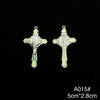 A pair of St. Benedict crucifix pendants featuring a cross design with a green enamel finish.