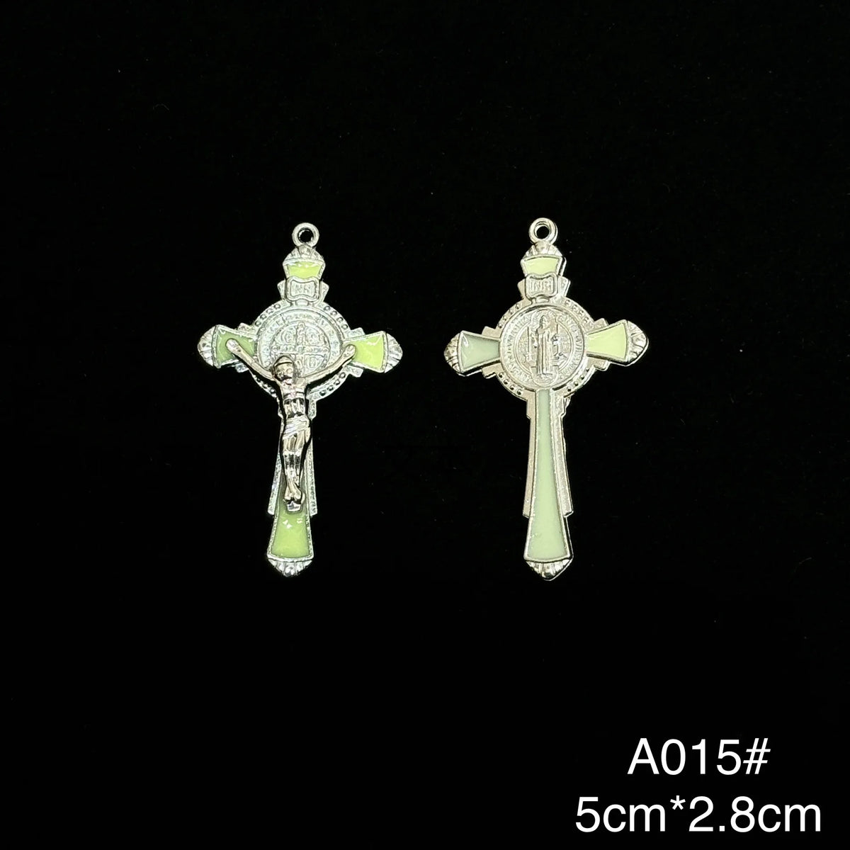 A pair of St. Benedict crucifix pendants featuring a cross design with a green enamel finish.