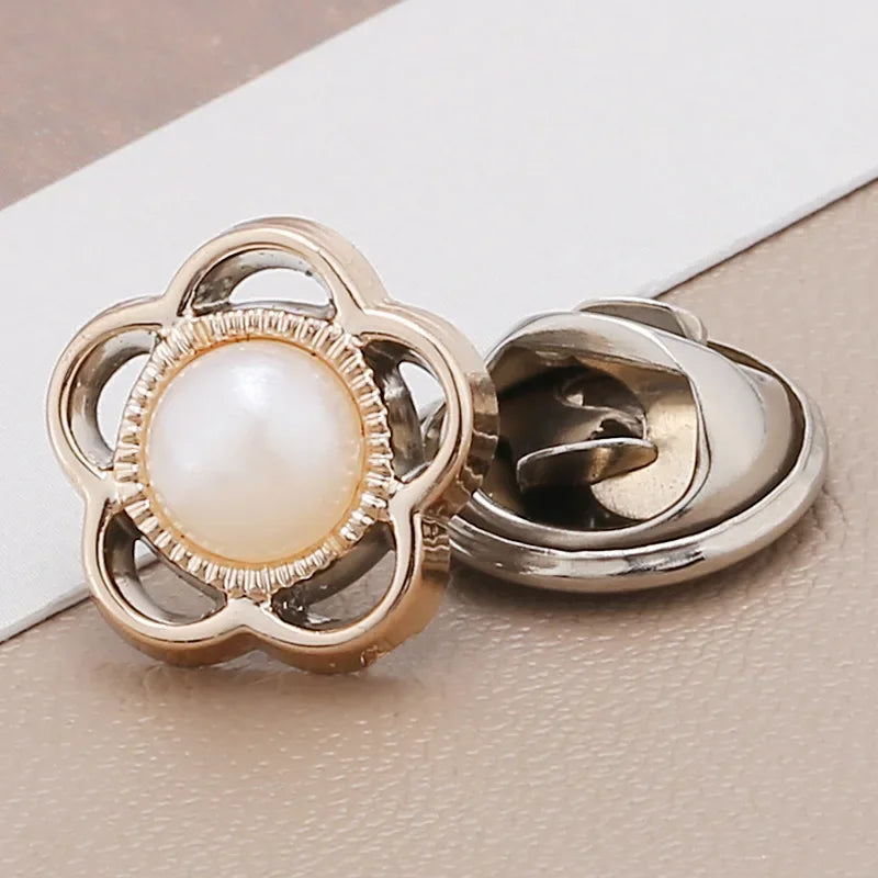 A pair of gold-toned and silver-toned pearl and rhinestone no-sew brooch buttons.