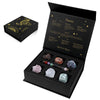 A black gift box containing a natural stone zodiac bracelet and various crystals, with a separate box featuring Taurus inform
