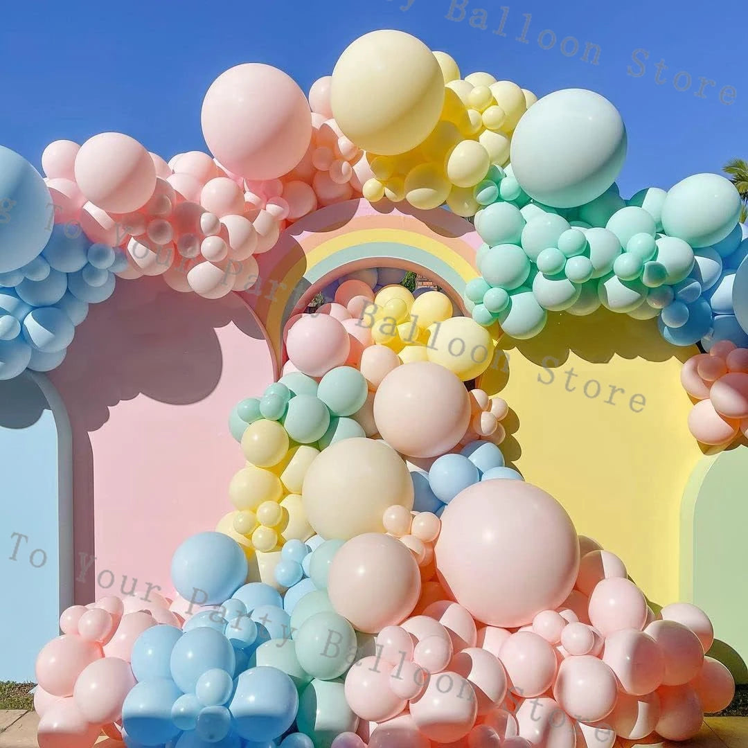 A balloon garland arch featuring pastel pink, yellow, and blue balloons for a party decoration.