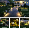 Decorative outdoor pathway lights illuminating a stone walkway leading to a house and garden area.