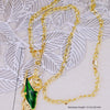 A gold-plated pendant necklace featuring a figure of Saint Jude, set against a white lace background.