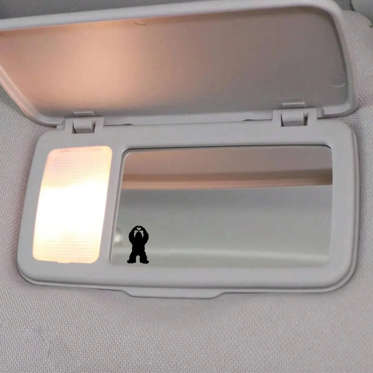A white vinyl decal featuring a silhouette of Bigfoot's hands on a clear plastic cover.