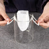 Hands holding white disposable coffee filter bags over a glass container for pour-over brewing