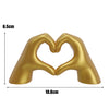 Gold heart shape sculpture made of hand-like forms for home decor and gifting