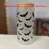 A white glass cup decorated with black bat silhouette vinyl stickers.